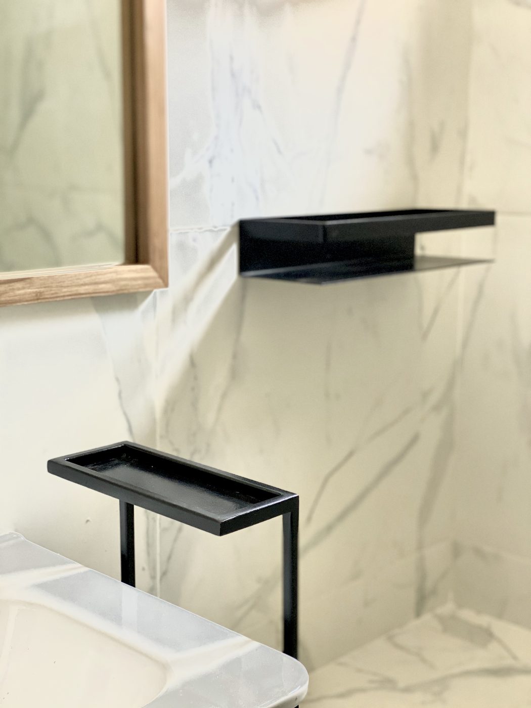 Obra Doblas: baño con revestimiento símil mármol y accesorios negros