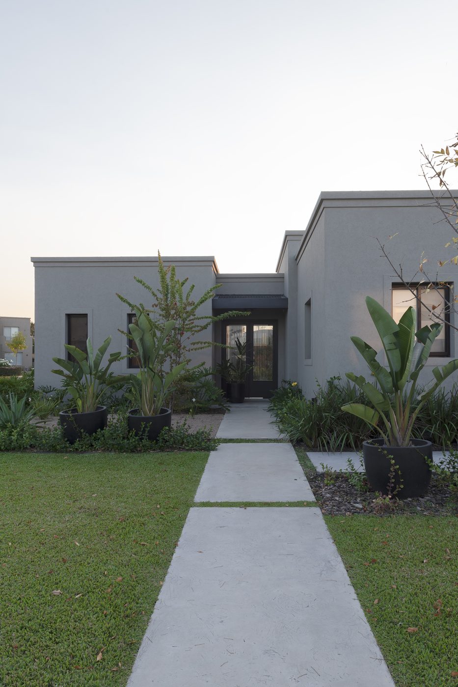 Casa San Rafael: frente con camino de hormigón y jardín